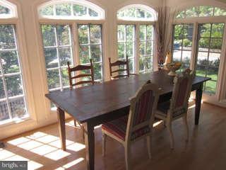 7403 Denton Road Bethesda, MD 20814 - Photo 12 of 25 a view of a dining room with furniture large windows and wooden floor