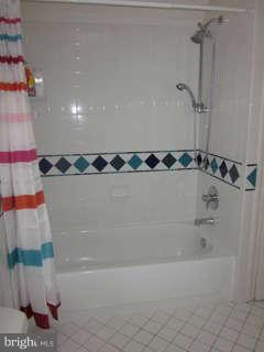7403 Denton Road Bethesda, MD 20814 - Photo 19 of 25 a bathroom with a bathtub and a shower