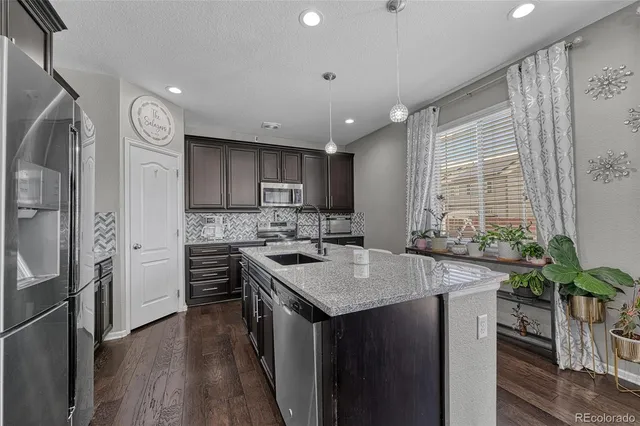 a kitchen with a refrigerator a sink and wooden cabinets