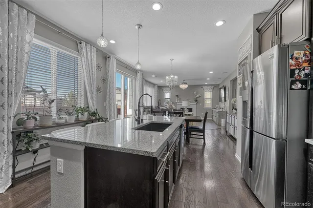 a kitchen with stainless steel appliances granite countertop a sink a stove and a refrigerator