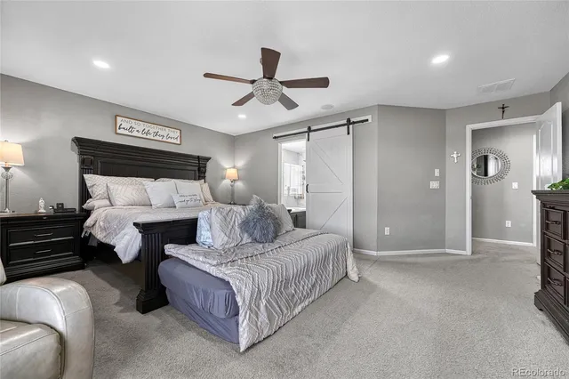 a spacious bedroom with a bed and ceiling fan