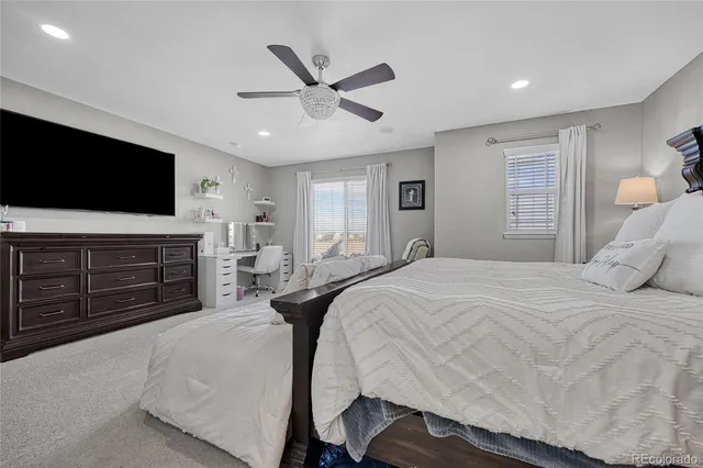 a spacious bedroom with a bed and a flat screen tv