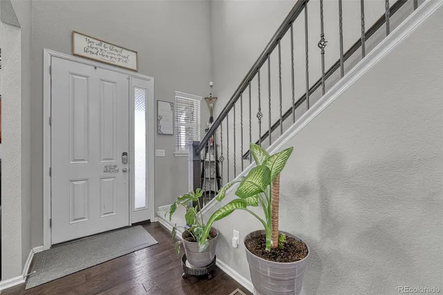 a dining room with furniture potted plants and wooden floor