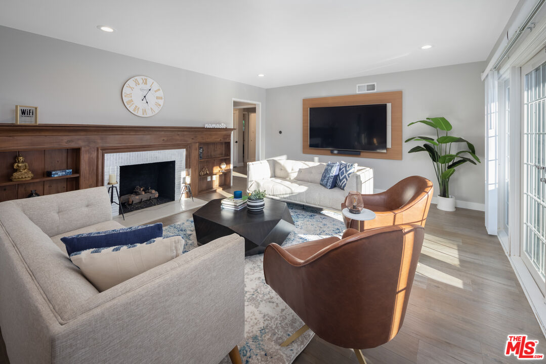 9476 Hidden Valley Place Beverly Hills, CA 90210 - Photo 14 of 43 a living room with furniture a flat screen tv and a fireplace