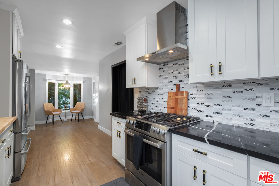 9476 Hidden Valley Place Beverly Hills, CA 90210 - Photo 17 of 43 a kitchen with stainless steel appliances a stove a sink and a refrigerator