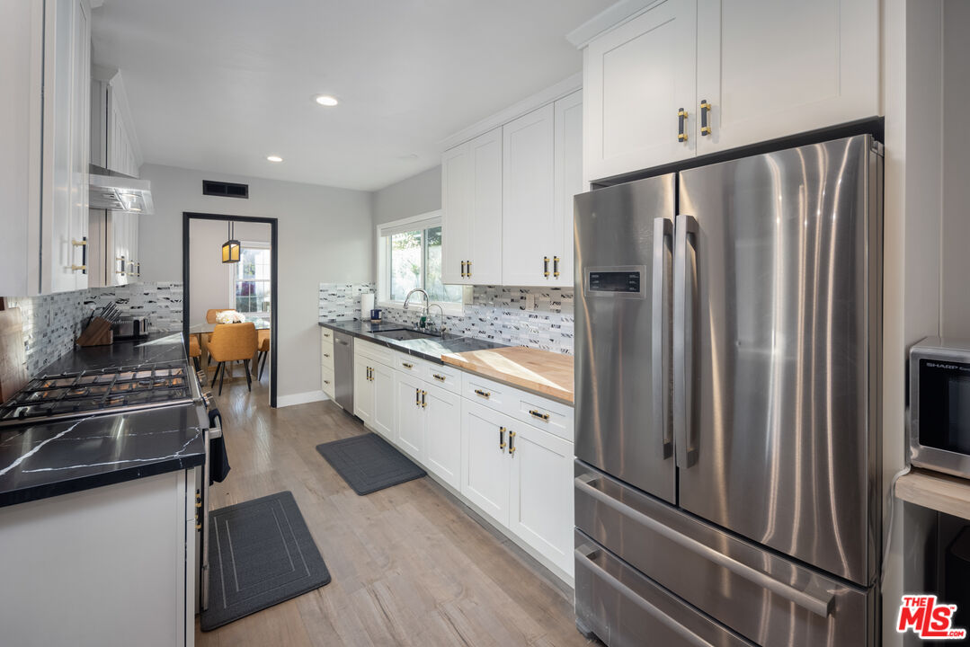 9476 Hidden Valley Place Beverly Hills, CA 90210 - Photo 19 of 43 a kitchen with stainless steel appliances granite countertop a refrigerator and a stove