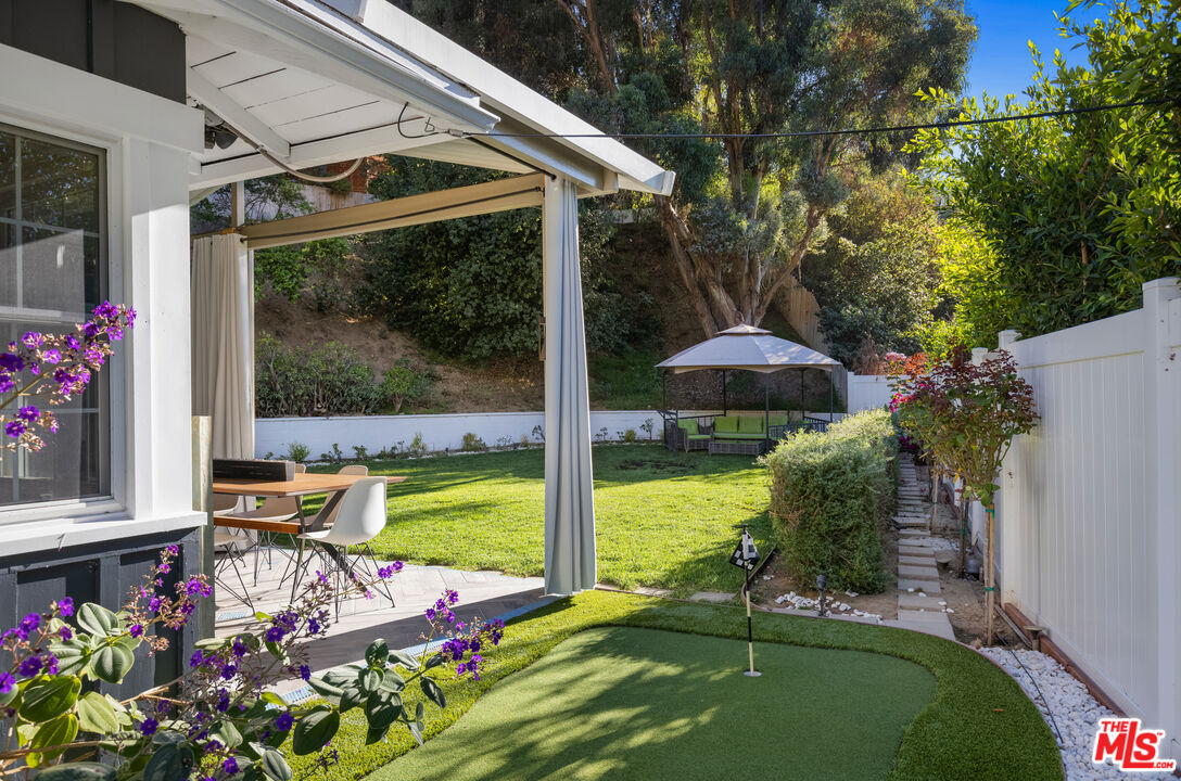 9476 Hidden Valley Place Beverly Hills, CA 90210 - Photo 20 of 43 a view of a patio with table and chairs potted plants with wooden floor