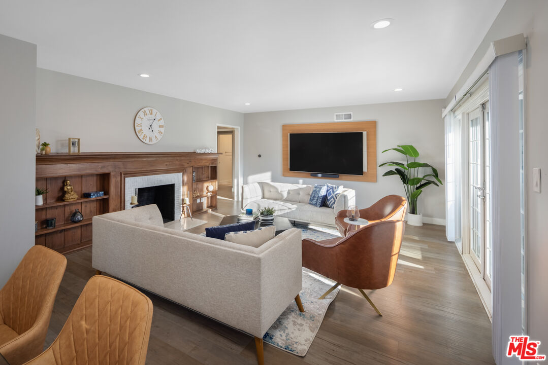 9476 Hidden Valley Place Beverly Hills, CA 90210 - Photo 21 of 43 a living room with furniture a fireplace and a flat screen tv