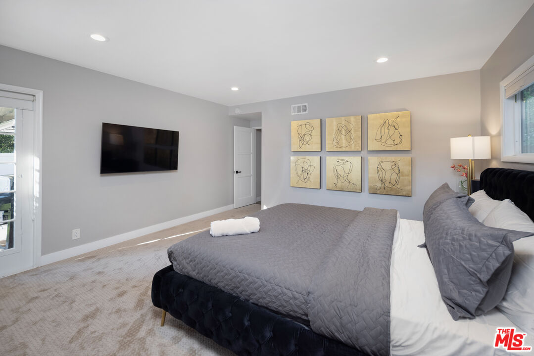 9476 Hidden Valley Place Beverly Hills, CA 90210 - Photo 23 of 43 a bedroom with a bed and a flat screen tv