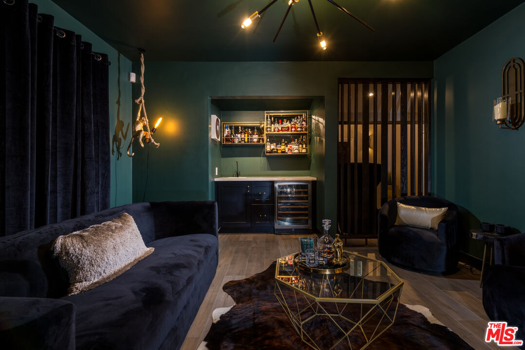 9476 Hidden Valley Place Beverly Hills, CA 90210 - Photo 34 of 43 a living room with furniture a projector and a flat screen tv