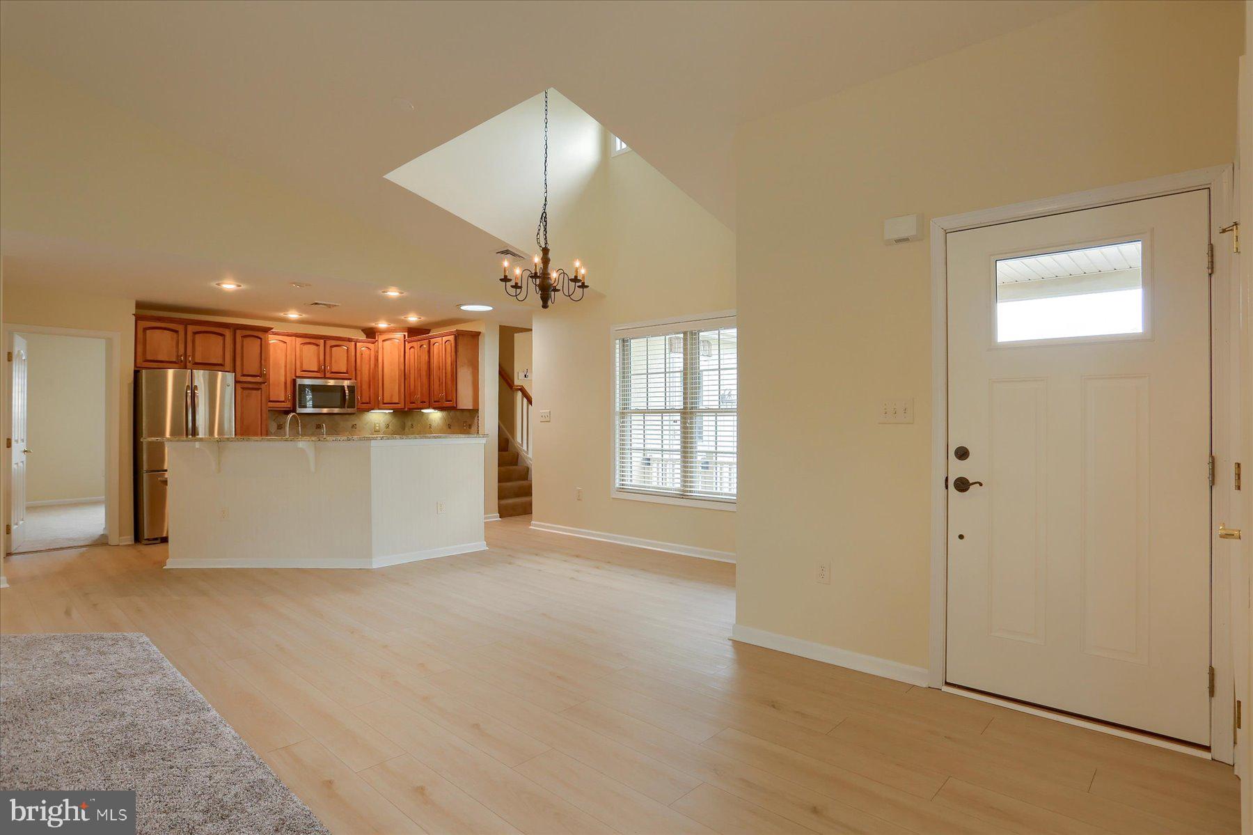 802 Heather Ridge Manheim, PA 17545 - Photo 5 of 41 an empty room with wooden floor kitchen view and a kitchen