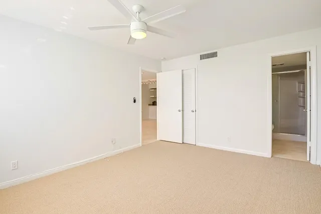 an empty room with a ceiling fan and a window