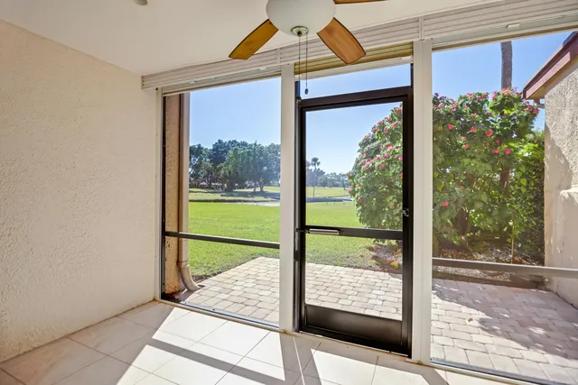 a view of a room with a large window and wooden floor