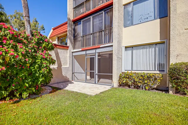 a view of a house with potted plants and a bench