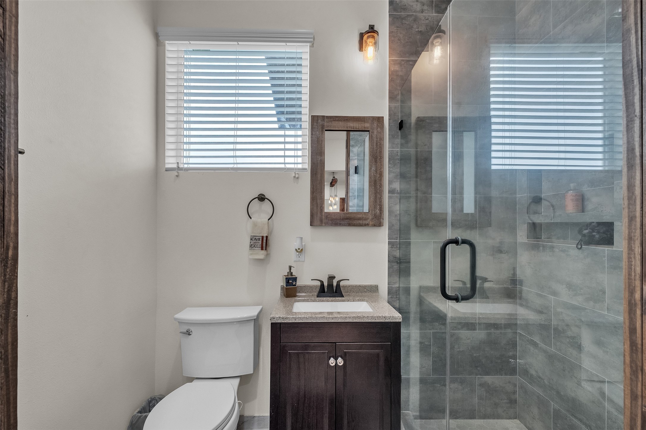 1048 11th Street Columbus, TX 78934 - Photo 27 of 48 a bathroom with a granite countertop sink toilet and shower