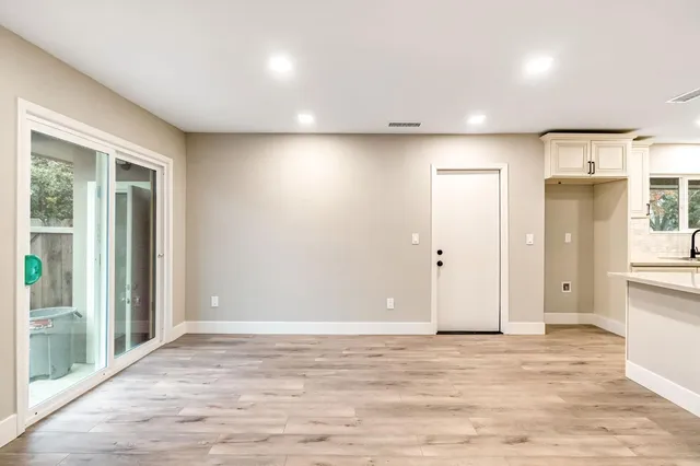 an empty room with wooden floor and windows