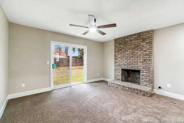 an empty room with fireplace and fan