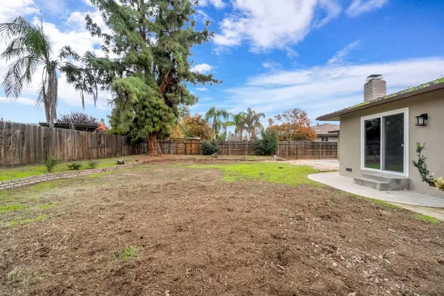 a view of a house with backyard and tree