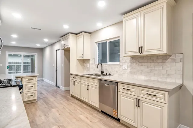 a kitchen with white cabinets and appliances