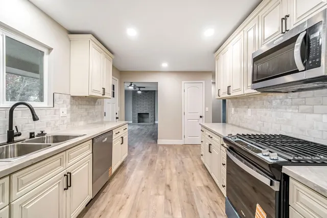a kitchen with stainless steel appliances a sink stove and cabinets