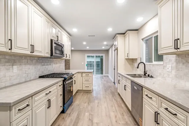 a kitchen with stainless steel appliances granite countertop a sink stove and cabinets