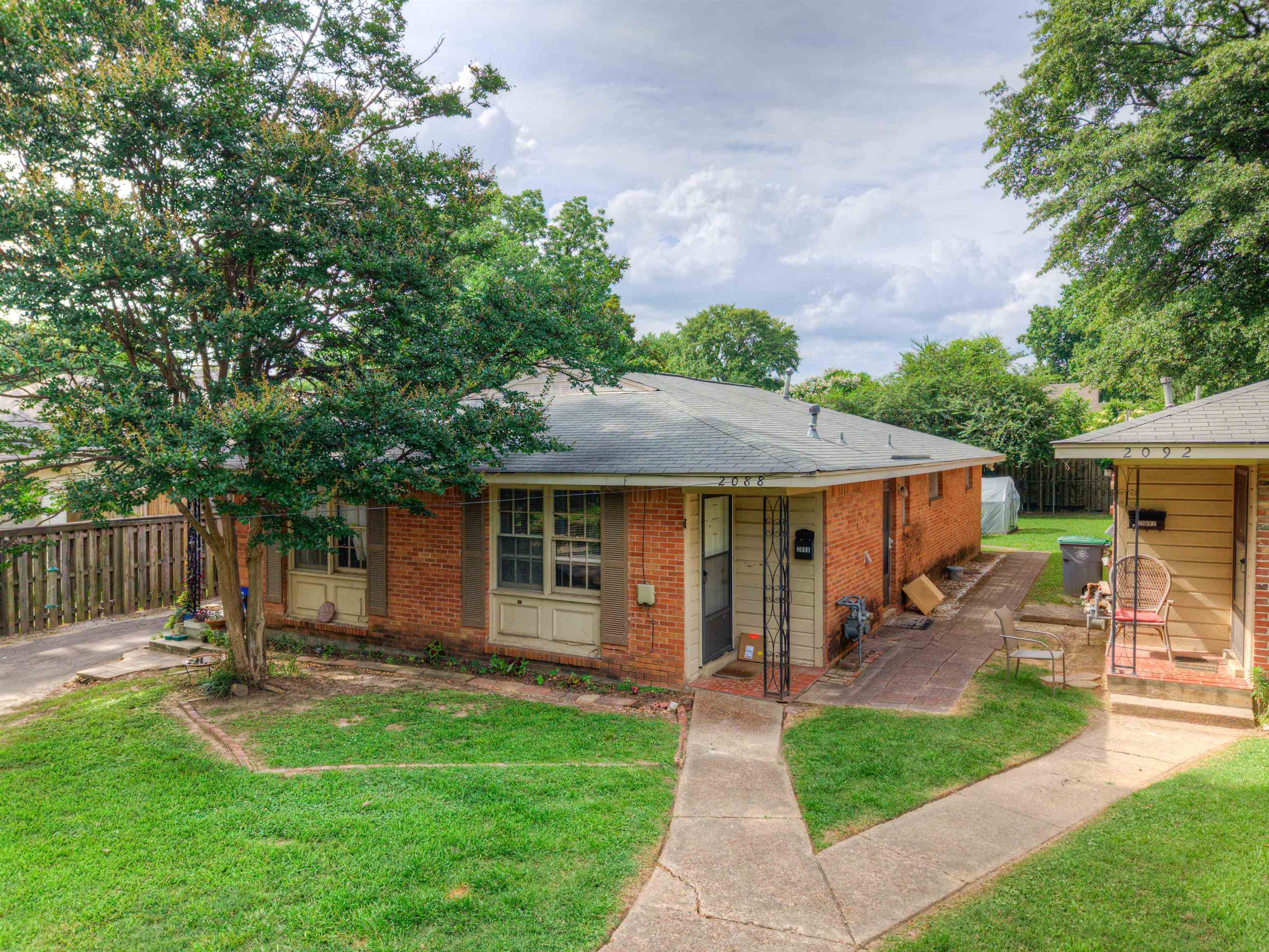 2086 Harbert Avenue Memphis, TN 38104 - Photo 1 of 16 a backyard of a house with table and chairs floor to ceiling window and wooden fence