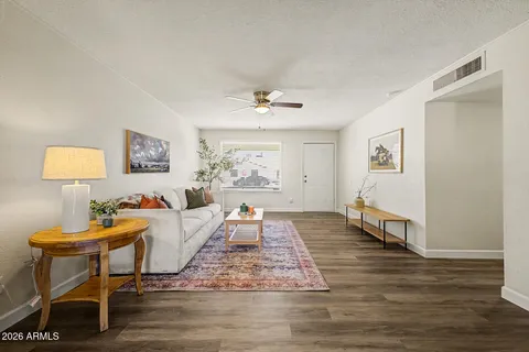 a living room with furniture and a wooden floor