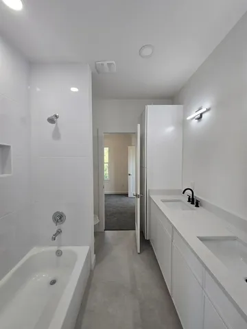 a bathroom with a tub a sink and mirror
