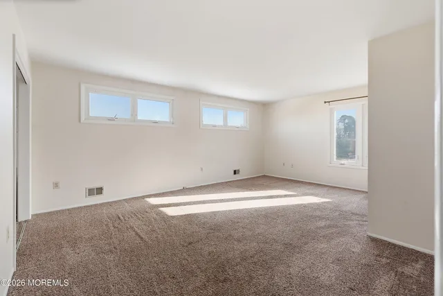 an empty room with a windows and closet