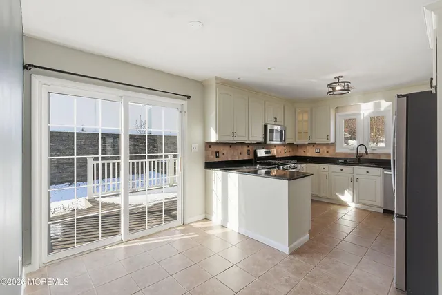a kitchen with stainless steel appliances granite countertop a stove a sink and a refrigerator