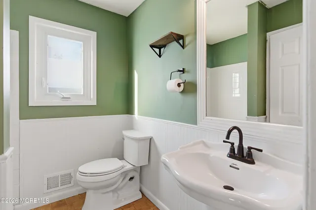 a bathroom with a sink and mirror with toilet