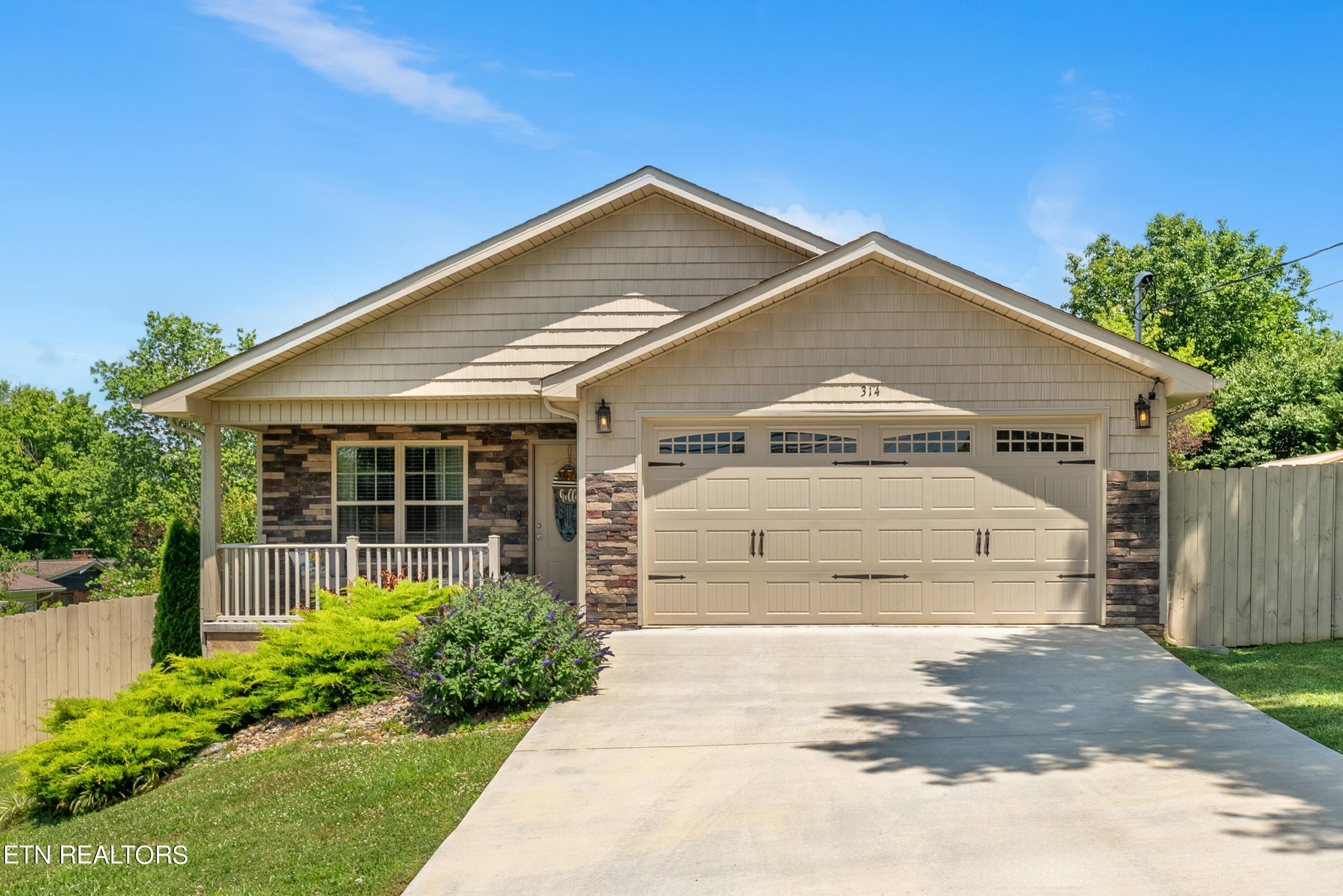 a front view of a house with a garden and garage