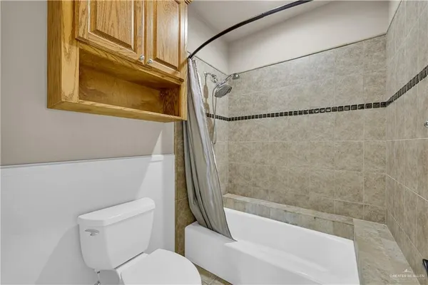 a spacious bedroom with a bed a couch and a chandelier