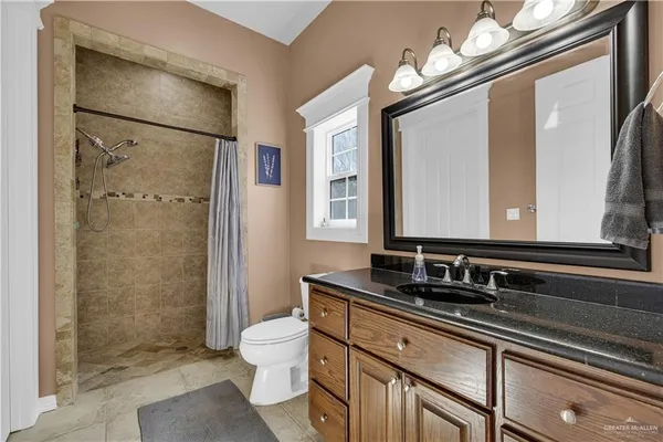 a bathroom with a sink a toilet and a large mirror