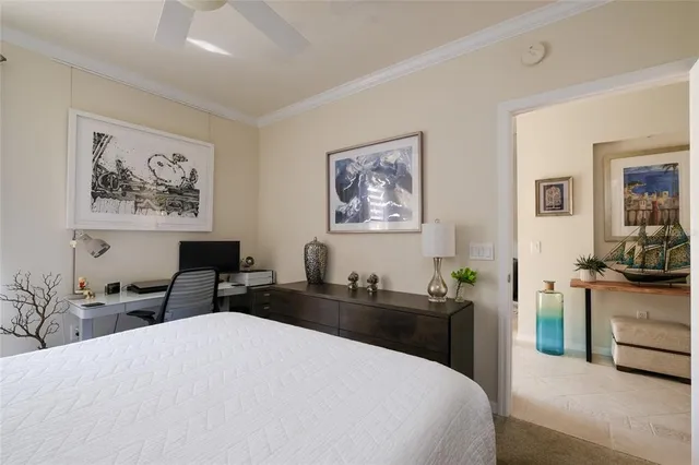 a bedroom with a bed couches and a flat tv screen