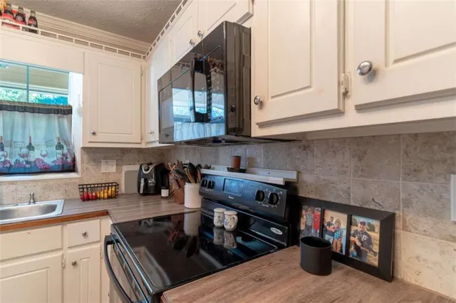 a kitchen with a stove and white cabinets