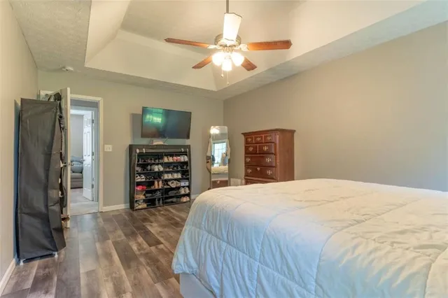 a bedroom with a bed and a flat tv screen on a dresser