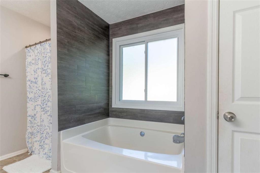 115 Woodland Ridge Circle Covington, GA 30016 - Photo 22 of 30 a white bath tub sitting next to a white sink