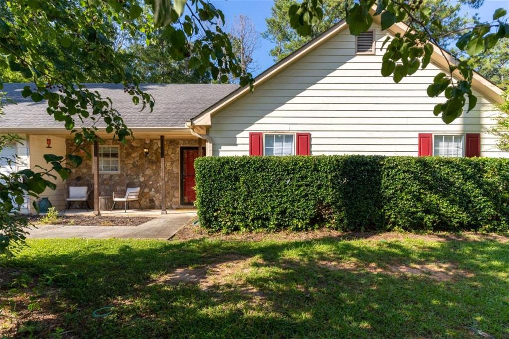 115 Woodland Ridge Circle Covington, GA 30016 - Photo 27 of 30 a view of a small house in a yard with potted plants