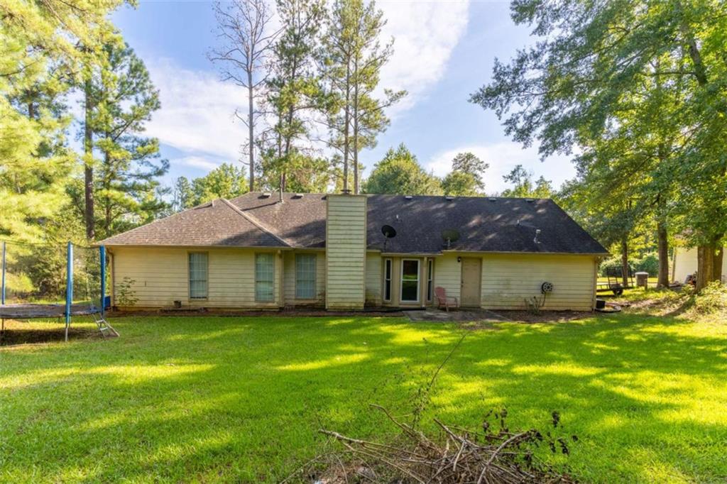 115 Woodland Ridge Circle Covington, GA 30016 - Photo 29 of 30 a yellow house with a big yard and large trees