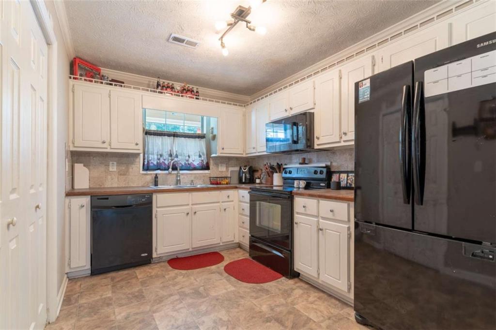 115 Woodland Ridge Circle Covington, GA 30016 - Photo 7 of 30 a kitchen with stainless steel appliances granite countertop a refrigerator sink and stove