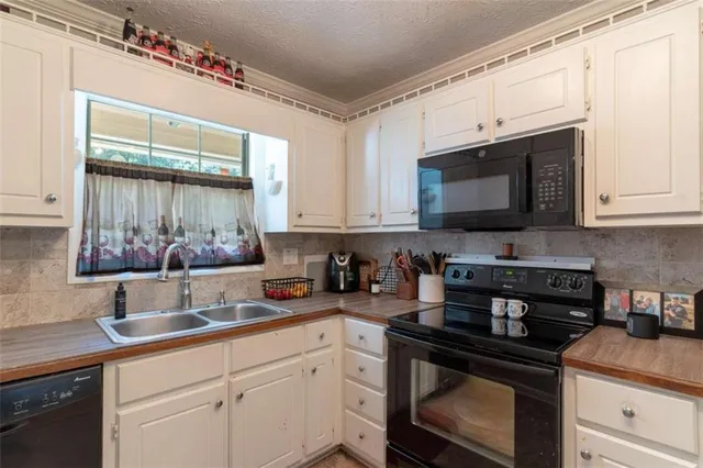 a kitchen with stainless steel appliances granite countertop a sink a stove microwave and cabinets