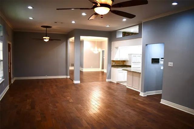 wooden floor in an empty room with a kitchen