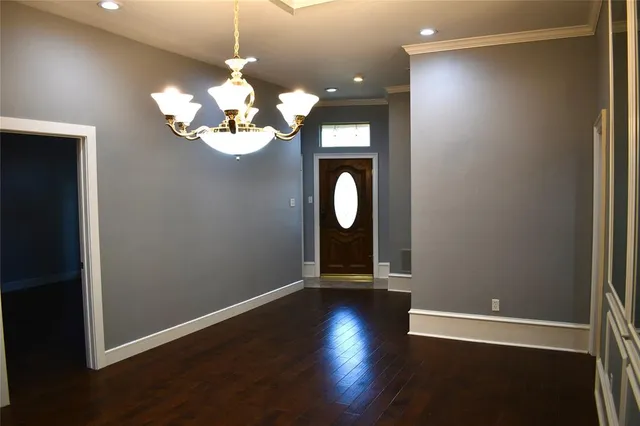 a view of a room with wooden floor and chandelier