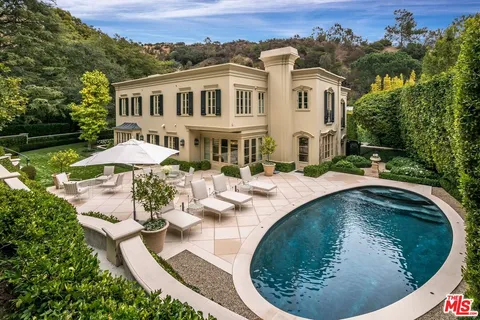 an aerial view of a house with outdoor space and trees