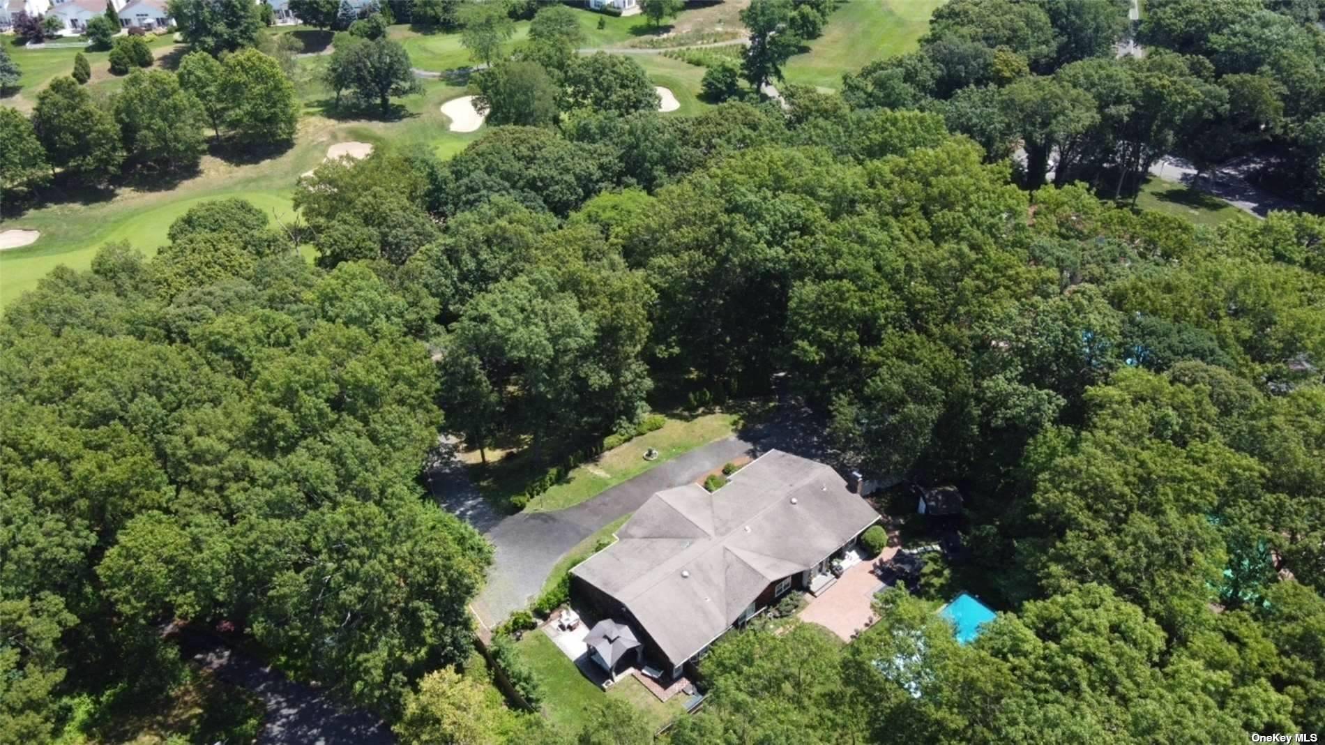 an aerial view of a house with a yard and outdoor seating