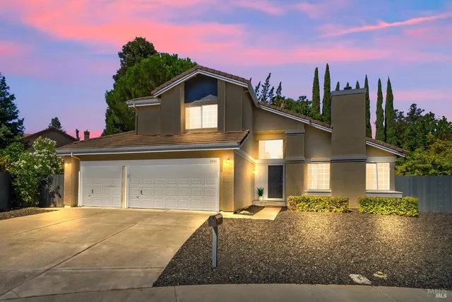 a view of a house with a yard and potted plants