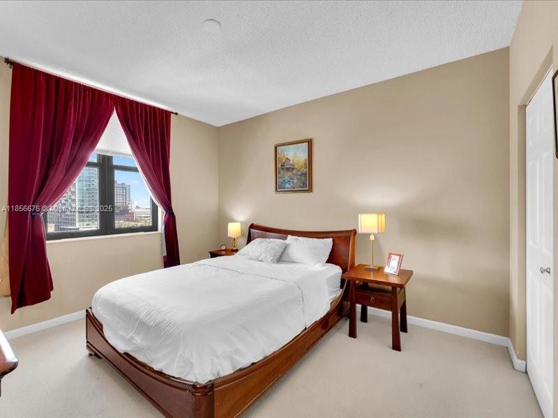 651 Okeechobee Boulevard, Unit 1002 West Palm Beach, FL 33401 - Photo 11 of 22 a bedroom with a bed and a window