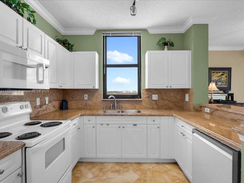 651 Okeechobee Boulevard, Unit 1002 West Palm Beach, FL 33401 - Photo 2 of 22 a kitchen with a sink stove and cabinets