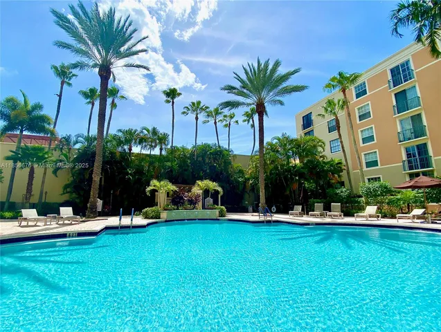 a view of a house with a yard and palm trees